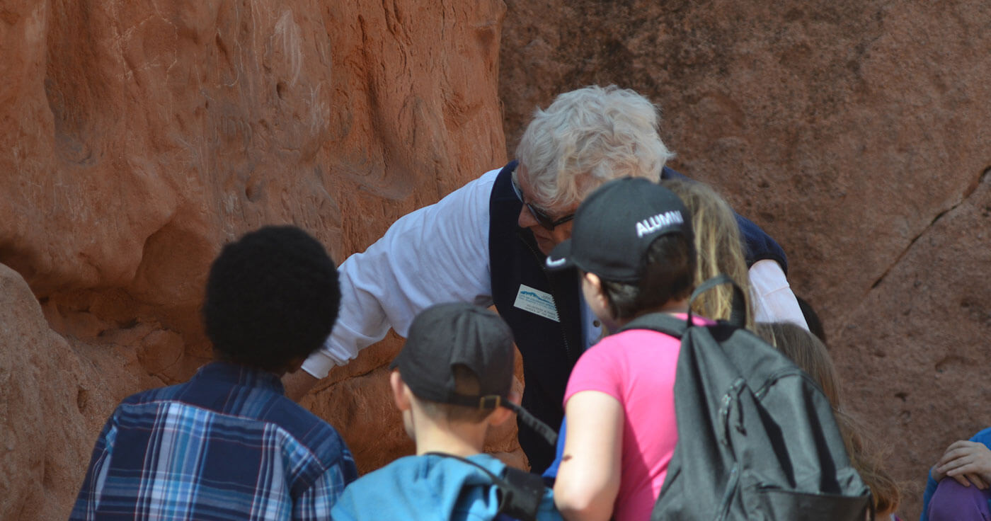 Guide and 3 children viewing red sandstone